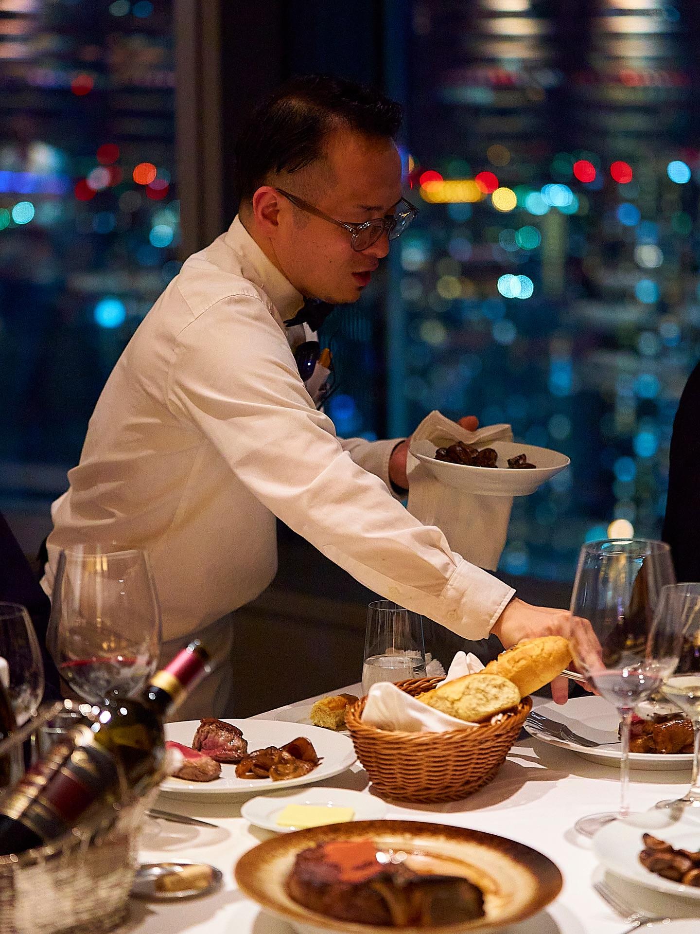 窓の外に広がるきらびやかな夜景、美しく並ぶ料理の数々。